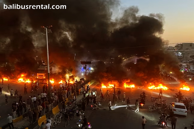 Protesters burn tires and other debris to block a highway during a demonstration over fuel price increases in Maarat al-Numan, Idlib province